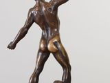 bronze statue of a man holding a book on top of a table