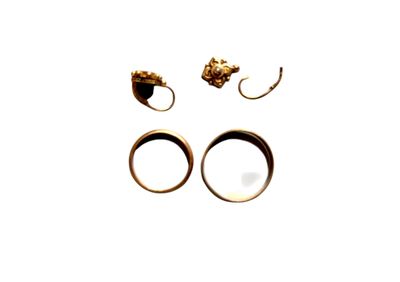 deux bagues et une paire de boucles d'oreilles posées sur une surface blanche