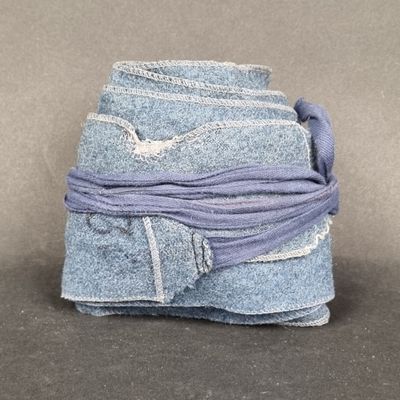 a stack of blue jeans tied together on a table