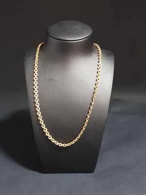 a gold chain necklace on a mannequin with a black background