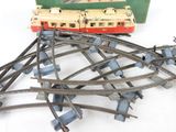 a toy train on the tracks next to a green box