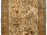 a beige and brown rug with birds and flowers on it