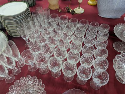 many glasses and plates on a table with a red table cloth