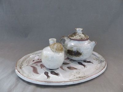 une assiette blanche sur laquelle sont posés une théière et une tasse
