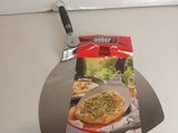 une boîte de pizza posée sur un plan de travail, à côté d'un coupe-pizza