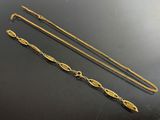 two gold chains and a long chain on a table