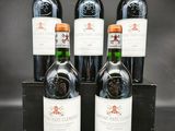 trois bouteilles de vin rouge dans un coffret en bois sur fond noir