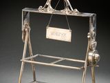 une vitrine ancienne plaquée argent, avec une pancarte accrochée sur le côté