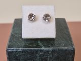 a close up of a pair of earrings sitting on top of a marble block