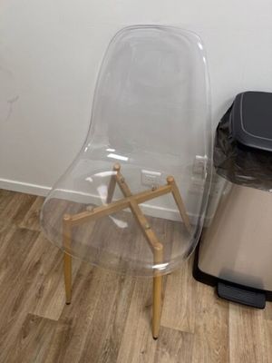 une chaise en plastique posée par terre à côté d'une poubelle