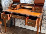 un bureau en bois à deux tiroirs et un miroir accroché au mur