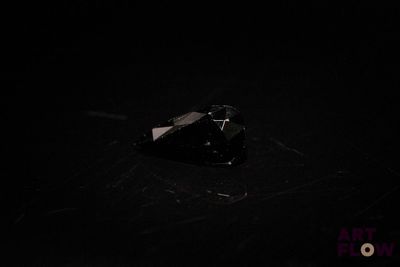 a piece of glass on the floor of a dark room