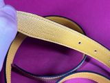 a person holding a belt that is on a purple surface