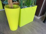 deux jardinières jaunes contenant des plantes, posées sur une table