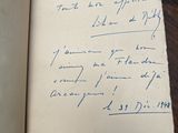 an open book on a table with a handwritten note on it