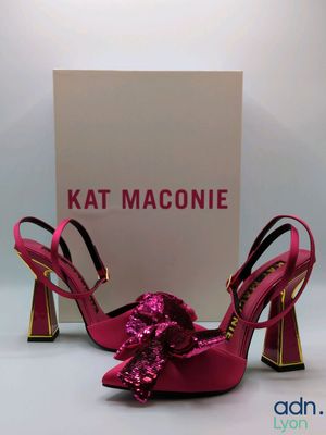 the pink shoes are next to a box with a pink bow on it