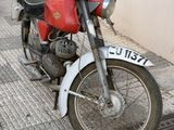 a red and white motorcycle parked on the side of the street