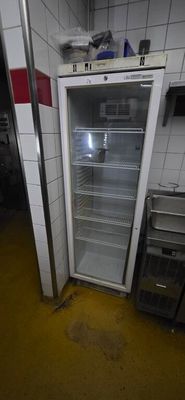 an image of a refrigerator in a kitchen with a dirty floor