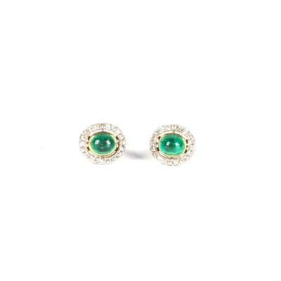 une paire de boucles d'oreilles en émeraude et diamant sur fond blanc