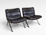 pair of black leather lounge chairs with chrome legs on a white background