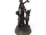 une statue antique en bronze représentant une femme et deux chiens, posée sur un socle