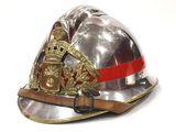 un casque de pompier argenté orné d'un ruban rouge