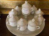 a white plate with cups and saucers on it on a table