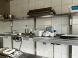 une cuisine équipée d'étagères en acier inoxydable et d'un évier