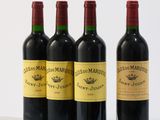 trois bouteilles de vin rouge sont posées les unes à côté des autres sur une surface blanche
