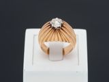 gros plan d'une bague en or surmontée d'un diamant