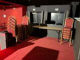 plusieurs chaises et une table dans une pièce recouverte d'un tapis rouge