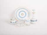 une table blanche avec une assiette bleue et blanche et deux bougeoirs