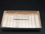 a silver tray with a pen in it on a black surface