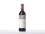 a bottle of red wine sitting on top of a white table