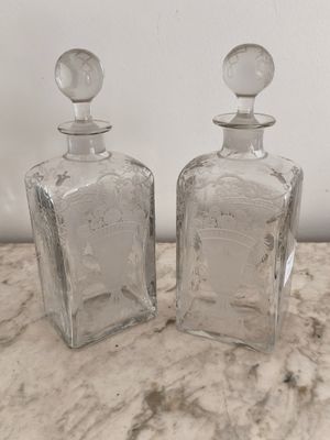 deux bouteilles en verre transparent posées sur un plan de travail en marbre