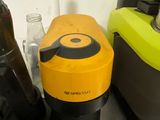 yellow and black blender sitting on top of a counter next to a bottle