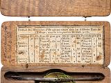 une vieille boîte en bois munie d'une plaque en laiton et contenant une boussole
