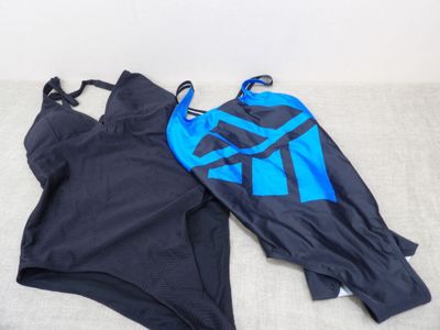 two swimsuits are laying on the floor next to each other