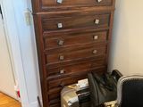 a chest of drawers with luggage on top of it