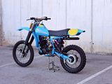 a blue dirt bike parked in a parking lot