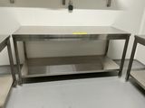 une table de travail en acier inoxydable dans une cuisine, avec deux chaises