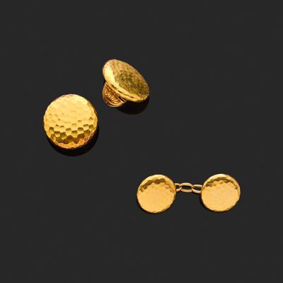 un gros plan sur une paire de boutons de manchette en or et une paire de boucles d'oreilles