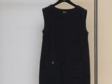 a black dress hanging on a clothes rack in a room