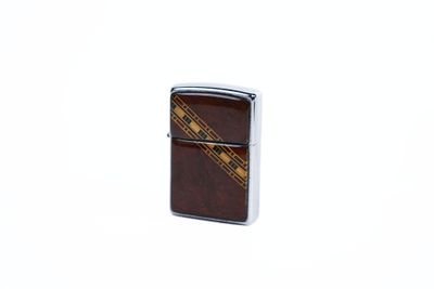 briquet Zippo orné d'un motif marron et doré sur le devant