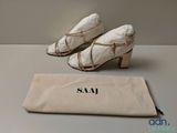 the pair of shoes are sitting next to a bag on the table