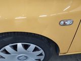 a yellow car that is parked in a parking lot