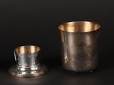 a silver cup and saucer on a black background