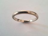 gros plan d'une bague en argent sur une surface blanche