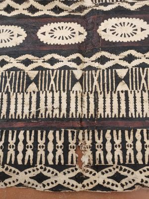 un gros plan d'un tapis noir et blanc posé sur un parquet