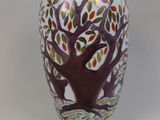 un vase blanc orné d'un motif représentant un arbre violet